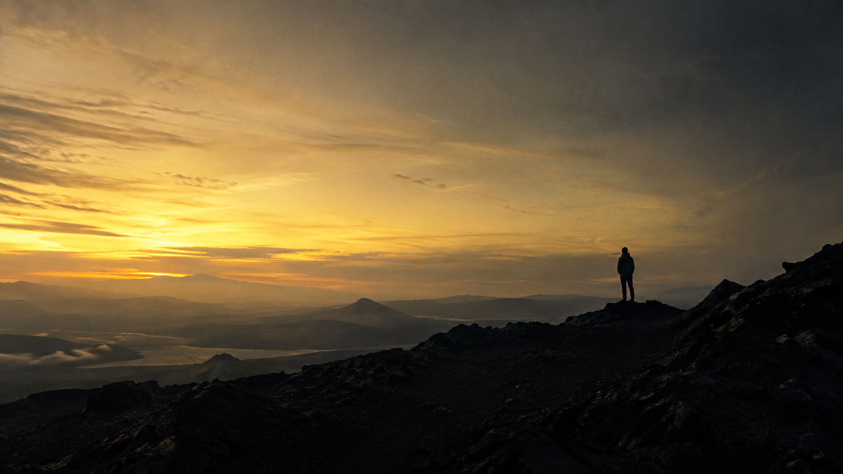 A silhouette on a dark volcanic hill under a golden sky; an Opal Grade concept study